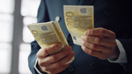 Pack euro bills counting by unknown successful business man close up. Male hands calculating paper banknotes european currency denomination of two hundred. Financial income profit investment concept.の写真素材