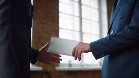 Business men exchange envelope concluding successful deal on office meeting closeup. Unknown manager...