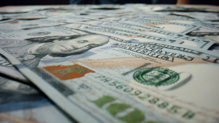 Hundred dollars banknotes falling on table close up. Paper bills american currency scattering on surface. Many 100 usd with image Benjamin Franklin lying on large heap. Usa money cash background.の写真素材