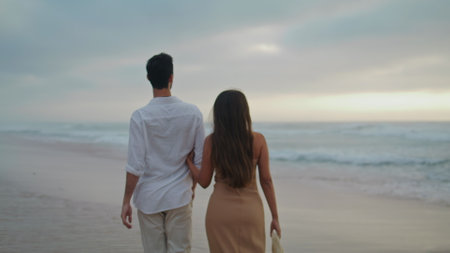 Loving couple crossing seashore at summer closeup. Positive spouses enjoying ocean. Affectionate newlyweds feeling happy spending honeymoon together. Relaxed people talking at sea. Vacation conceptの写真素材