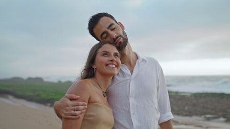 Lovely family cuddling at misty ocean closeup. Happy woman man walking on dusky beach. Affectionate sweethearts enjoying each other at foggy sea shore. Young couple spending honeymoon togetherの写真素材
