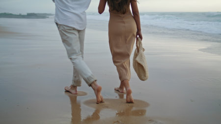 Couple legs crossing ocean at summer closeup. Affectionate spouses enjoying seashore. Positive newlyweds feeling happy spending honeymoon together. People rest at foggy coast. Vacation conceptの写真素材