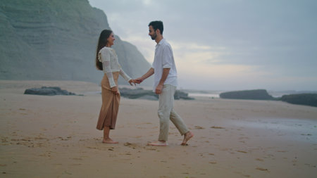 Romantic man proposing marriage to woman at evening beach. Young lovers enjoying time together. Enamoured guy kneeling down with wedding ring at seashore. Emotional couple celebrating engagementの写真素材