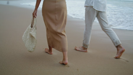 Sweethearts feet running sand beach at sea vacation. Unrecognizable playful couple walking on shore...