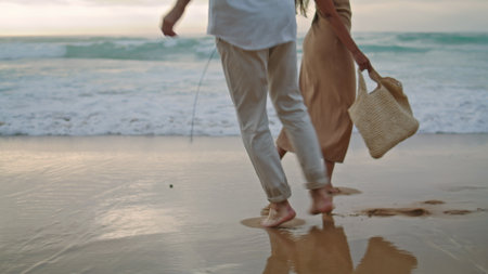 People feet walking sand beach at sea vacation. Unrecognizable playful couple stepping on shore outdoors. Closeup two lovers legs going out nature landscape background. Relax recreation conceptの写真素材