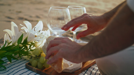Man hands relaxing picnic on summer beach closeup. Unknown guy breaking bread at sunlight coastline. Male tourist preparing eating on ocean nature. Boy enjoying food served on blanket for dateの写真素材
