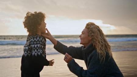 Little kid talking phone on ocean shore. Happy mother giving smartphone to son enjoying distance conversation with partner husband. Excited child calling parent. Loving family lifestyle relationshipsの写真素材