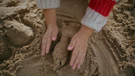 Kid hands building sand castle on seashore weekend. Creative boy enjoying game resting beach. Unrecognized toddler girl learning having fun on autumn holidays alone. Preschool development concept.の写真素材