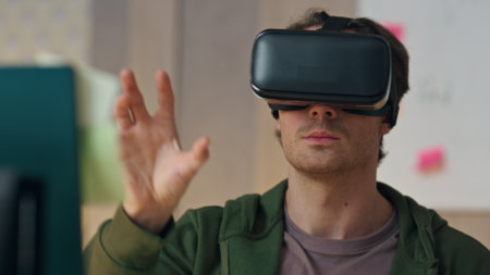Closeup man testing vr glasses program at office. Virtual reality headset freelancer gesturing hands moving invisible objects indoors. Creative smart game designer working in augmented reality aloneの写真素材