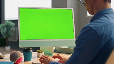 Freelancer using green screen computer in office close up. Unrecognizable business man working chroma key device keyboard. Formal shirt guy preparing conference texting mockup display pc at cabinetの写真素材