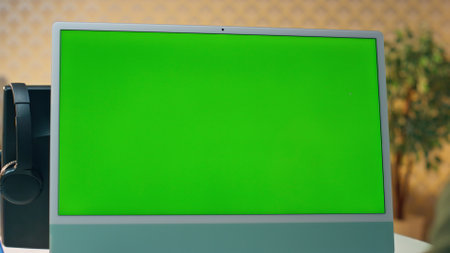 Man videocalling chromakey computer at table closeup. Unknown web designer having video conference explaining at green screen pc office. Unrecognizable creator talking online meeting at mockup deviceの写真素材