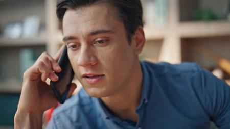 Nervous business man calling phone at room closeup. Annoyed office manager gesturing hands emotionally ending bad smartphone conversation. Angry freelancer having problems feeling stress at workの写真素材