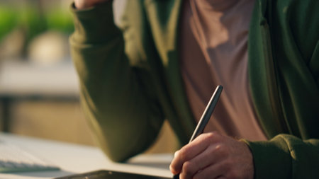Designer hand creating tablet at sunny workplace close up. Smiling creator calling smartphone at cozy office. Creative artist drawing graphic pad computer working indoors. Happy man talking cellphoneの写真素材