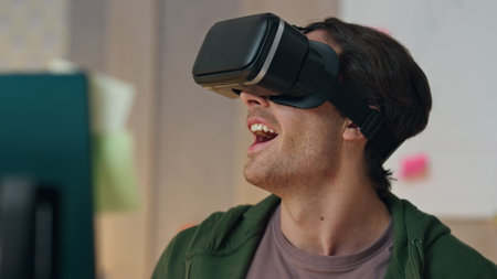 Excited man enjoying metaverse trying virtual reality headset at office closeup. Surprised designer testing games touching invisible interface. Shocked creator reacting emotionally at cyberspace worldの写真素材