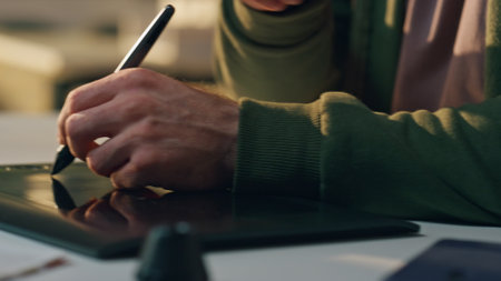 Designer hand creating tablet at sunny workplace close up. Smiling creator answering smartphone call working at cozy office. Creative artist drawing graphic pad computer. Happy man talking cellphoneの写真素材