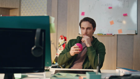 Pensive designer watching computer screen at business cabinet closeup. Thoughtful freelancer holding stylus looking for ideas at hipster apartment. Man creating project using tablet at design studioの写真素材