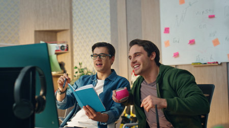 Happy designers virtual conference at coworking closeup. Smiling confident team video chatting with partners online. Positive colleagues joking with each other at distance desktop computer meetingの写真素材