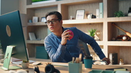 Thoughtful startuper staring computer screen at office. Close up serious creator man reading information holding ball at modern cabinet. Focused freelancer feeling attentive working at creative spaceの写真素材