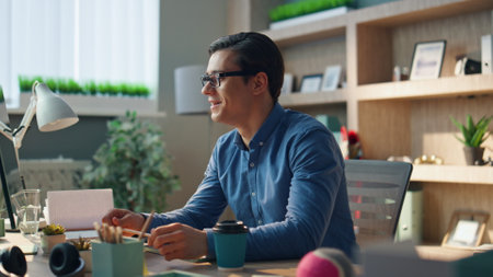 Startup guy video calling at room closeup. Closeup creative business man talking with positive expression enjoying virtual meeting in office. Happy designer consulting client in desktop computer chatの写真素材
