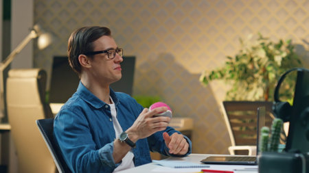 Happy freelancers giving five to each other at office closeup. Eyeglasses man communicating with colleague at computer table. Two smiling guys enjoying break in friendly atmosphere moving cameraの写真素材