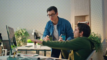 Creative freelancers pointing monitor at office. Eyeglasses inspired businessman gesturing...