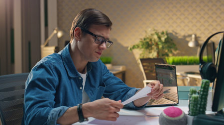 Overworked man drawing sketch showing to colleague closeup. Tired coworker guy declining ideas. Eyeglasses freelancer crumpling paper throwing away. Two colleagues working late together at office roomの写真素材
