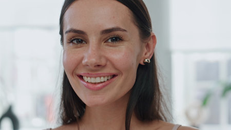 Pov cheerful girl posing in bathroom. Portrait satisfied happy woman in earrings looking camera at home. Longhaired smiling model in new accessories closeup. Self esteem and female beauty conceptの写真素材