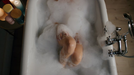 Relaxed lady bathing candles room place top view. Sexy girl taking foamy bathtub washing at evening luxury hotel interior. Pretty carefree woman enjoying spa procedures laying hot water at homeの写真素材