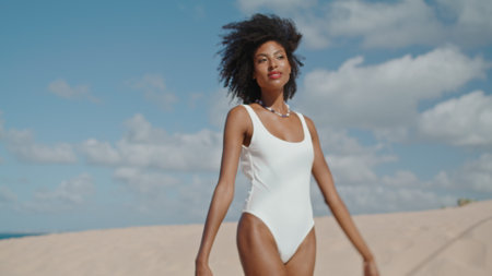 Attractive woman relaxing beach at ocean shore. Joyful slim girl enjoy sunlight posing in bikini on summer vacation. Happy romantic african american rest at sunny seaside. Freedom enjoyment concept.の写真素材
