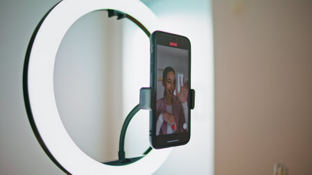 Closeup media person recording tutorial smartphone display view. Smiling woman talking at mobile...