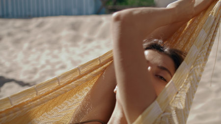 Closeup girl relaxing hummock in summer sunlight. Carefree woman resting beach enjoying seashore vacation. Beautiful gentle girlfriend posing dreaming on recreation resort. Chilling leisure concept.の写真素材