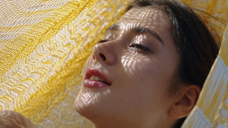 Portrait woman resting hammock in summer sunlight. Beautiful young girl posing enjoying summer vacation at seashore camping. Calm traveler relaxing peaceful weekend. Natural beauty femininity concept.の写真素材