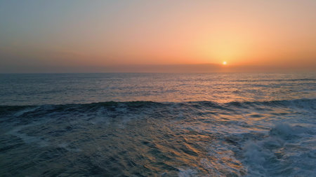 Powerful waves evening seascape slow motion. Foamy dark ocean surf breaking in nature view. Stormy marine landscape background in pastel sky horizon beach. Scenic dawn water surface in serene skylineの写真素材