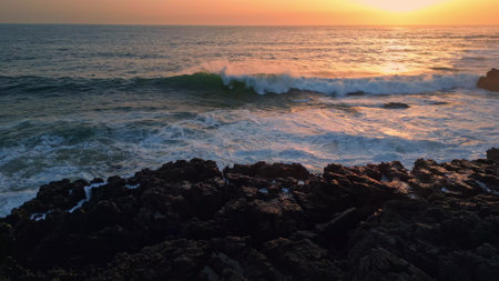 Morning ocean splashing cliffside nature closeup. Big waves crash volcanic rocks at remote shore slow motion. Cinematic foamy water violently breaking stoned coast of exotic island. Marine conceptの写真素材