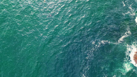 Closeup sea rippling surface reflecting sun beams. Aerial view yacht sailing to marine horizon slow motion. Lonely transport boat floating alone on calm ocean. Cruise ship travelling in open waterの写真素材