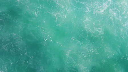 Turquoise ocean water waving agitated aerial view. Picturesque deep blue sea surface rippling making...