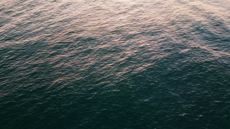 Closeup sea rippling surface reflecting morning sun. Drone view calm blue summer lagoon super slow...