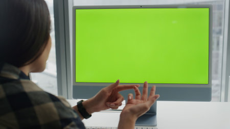 Woman speaking chromakey device indoors closeup. Young specialist working mockup pc online at city view home. Unrecognizable startuper presenting creative project at green screen computer video callの写真素材