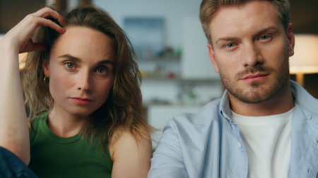Focused pair staring tv show at home closeup. Calm man hand holding remote controller changing...