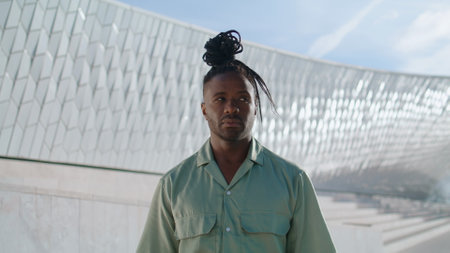 Ballet dancer posing stadium portrait. African american guy standing after solo performance at open air place. Black hair artist looking camera at modern space closeup. Contemporary lifestyle conceptの写真素材