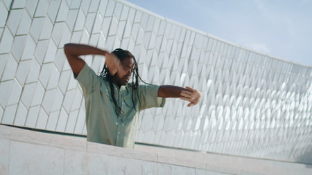 Inspired dancer doing performance rehearsal at stadium. Sensual man training contemp dance moves closeup. African american guy practicing freestyle at urban abstract place. Artistic people conceptの写真素材