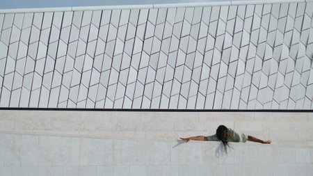 Dramatic guy rehearsing dance street. Dramatic man express emotions alone. African american dancer showing performance improvisation near wall background. Talented artist dancing creative freestyleの写真素材