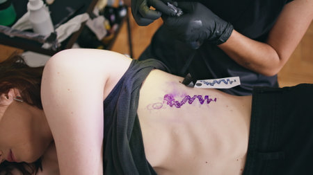 Tattooist hands assembling machine at salon closeup. Unrecognizable woman preparing to session at workplace. Involved tattoo artist holding work equipment in creative studio. Art process conceptの写真素材