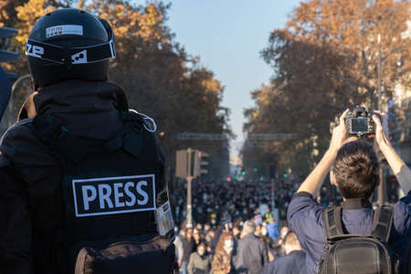 Paris, France - November 28th 2020: at the march against the global security law, journalist wearing a helmet watching at the huge crowd coming inのeditorial素材