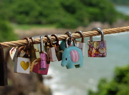 The Color love padlock locked on rope bridgeÂ bridge. Symbol of marriage and eternal love.Belief of people that their love will be as strong as pair of lock which still there from time to time.の写真素材