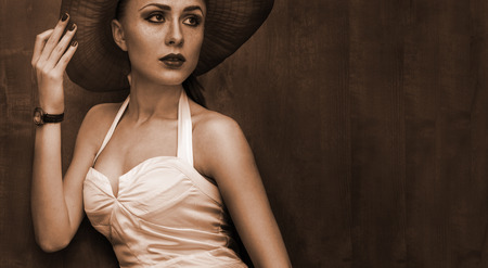 beautiful woman in hat with red lips posing before cameraの写真素材