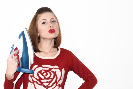 Smiling young girl ironing with iron isolated on white backgroundの写真素材