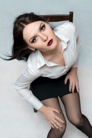 beautiful girl posing on a chair in the studio