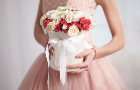 Gentle bride in a pink dress with beautiful flowers in rose quarz and serenity colorsの写真素材