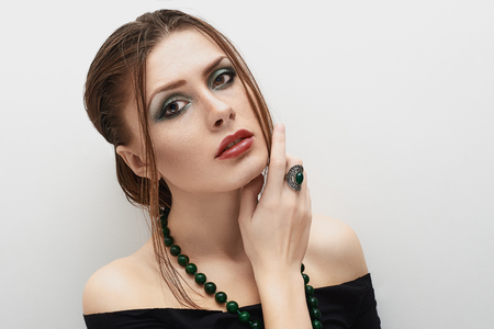beauty girl posing on the white background with beads and bare shouldersの写真素材